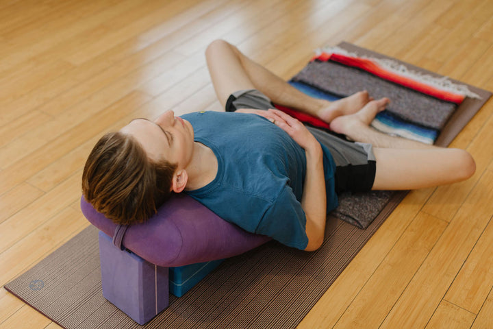 A man sits in a restorative yoga pose at Rocksteady Bodyworks in Holladay, Utah.